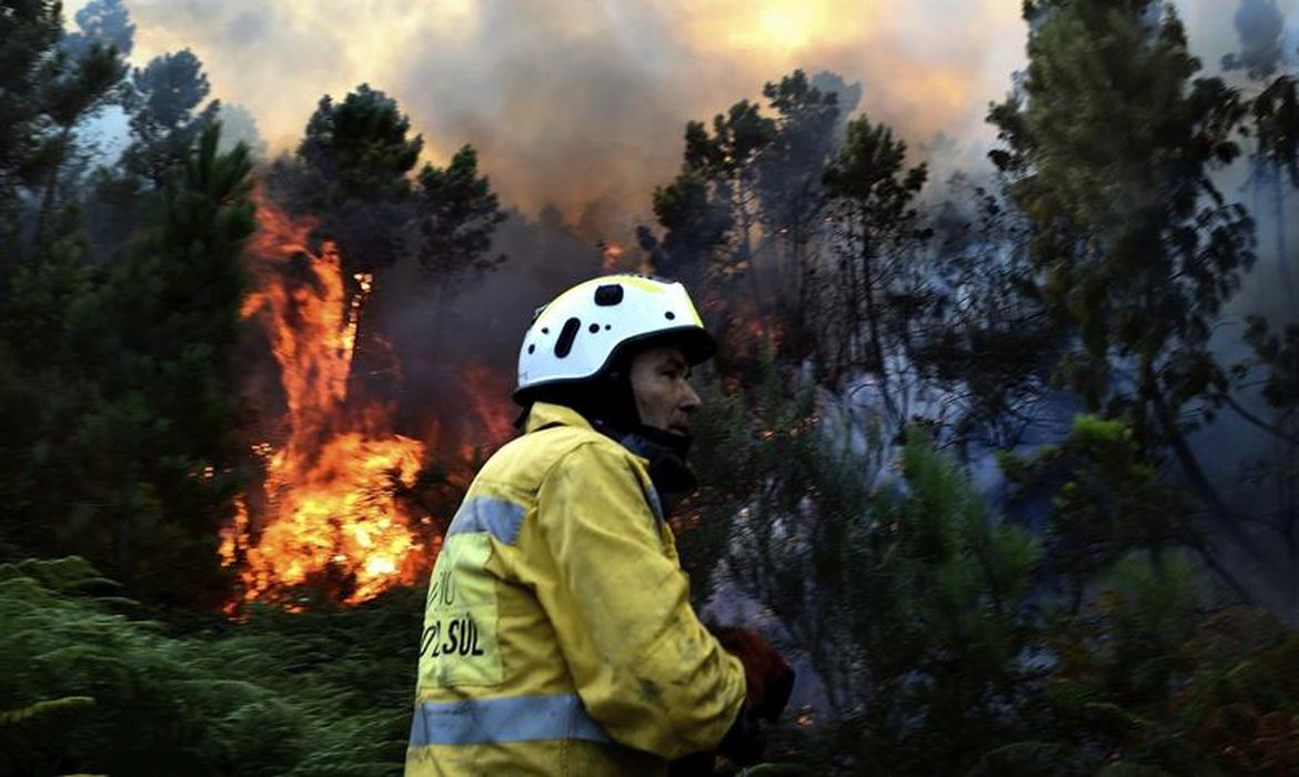 Bombeiro trabalha para apagar as chamas de incêndio nas montanhas de Manhouce, em São Pedro do Sul, Portugal