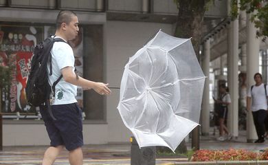 A man makes his way amid strong wind by typhoon Krosa in Miyazaki in this photo taken by Kyodo August 14, 2019. Mandatory credit Kyodo/via REUTERS Mandatory credit Kyodo/via REUTERS ATTENTION EDITORS - THIS IMAGE WAS PROVIDED BY A THIRD PARTY.