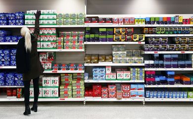 Consumidora tenta alcançar caixa de chá em supermercado, em Londres, Reino Unido