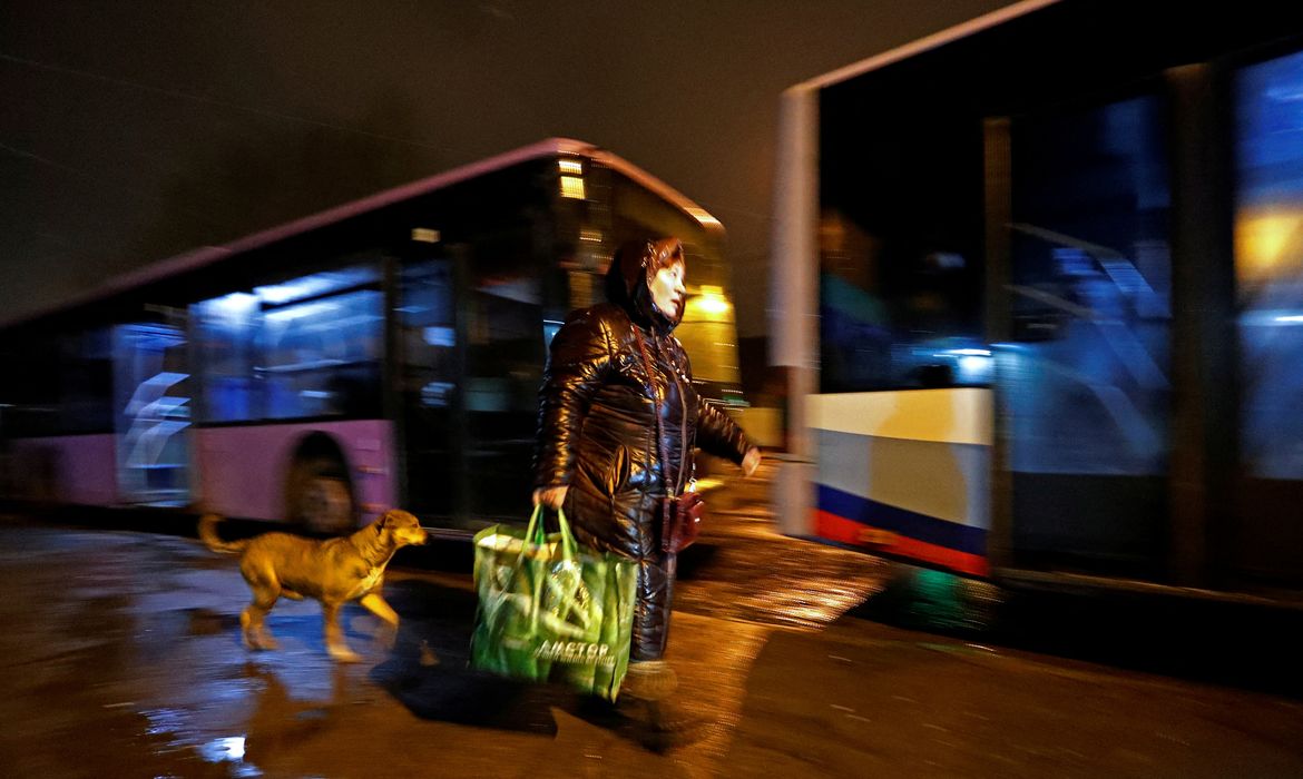 Mulher em Donetsk se prepara para entrar em ônibus para retirada da região