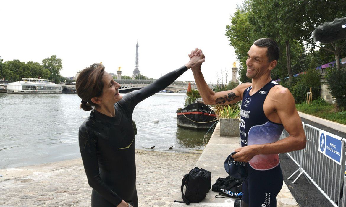 Amélie Oudéa-Castéra ao lado do atleta de Triatlo Alexis Hanquinquant - eles nadaram no Rio Sena em 13/07/2024
