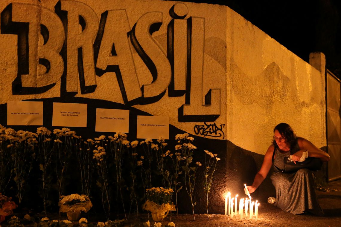 Uma mulher acende velas enquanto presta homenagem Ã s vÃ­timas do tiroteio na escola Raul Brasil em Suzano, SÃ£o Paulo, Brasil 13 de marÃ§o de 2019. REUTERS / Amanda Perobelli