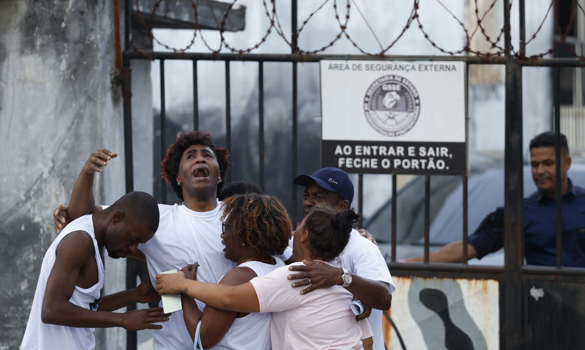 Rio de Janeiro (RJ) 25/07/2024 – Carlos Vitor Guimarães abraça sua família no lado de fora do Presídio Evaristo de Moraes. O jovem negro de 25 anos, morador de São Gonçalo, esteve preso durante um ano e meio ao ser condenado por roubo de carga apenas com reconhecimento por foto, e está absolvido pelo Superior Tribunal de Justiça após pedido da Defensoria Pública do Estado.  Foto: Fernando Frazão/Agência Brasil