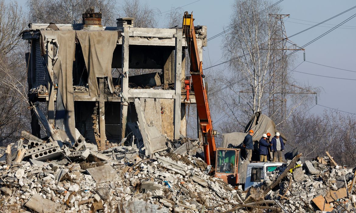Trabalhadores removem escombros de prédio usado por soldados russos e destruído por ataque de míssil ucraniano em  Makiivka, em área ucraniana controlada pela Rússia