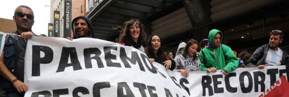 Manifestantes carregam faixa durante protesto pelas ruas de Madri, Espanha