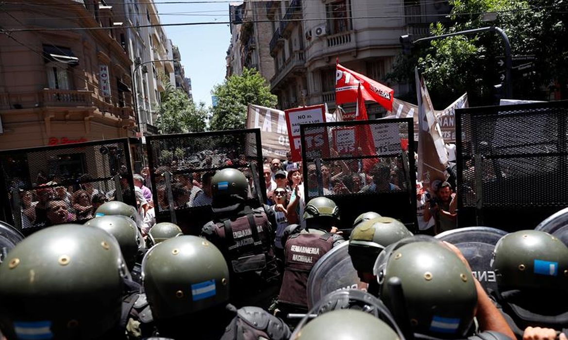Forças armadas argentinas contêm manifestantes, nos arredores do Congresso em Buenos Aires, que protestam contra a votação da reforma da Previdência no país