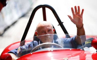 FILE PHOTO: Former English Formula One driver Stirling Moss waves to spectators as he sits in his 1955 Ferrari 750 Monza during the Ennstal Classic rally near Groebming