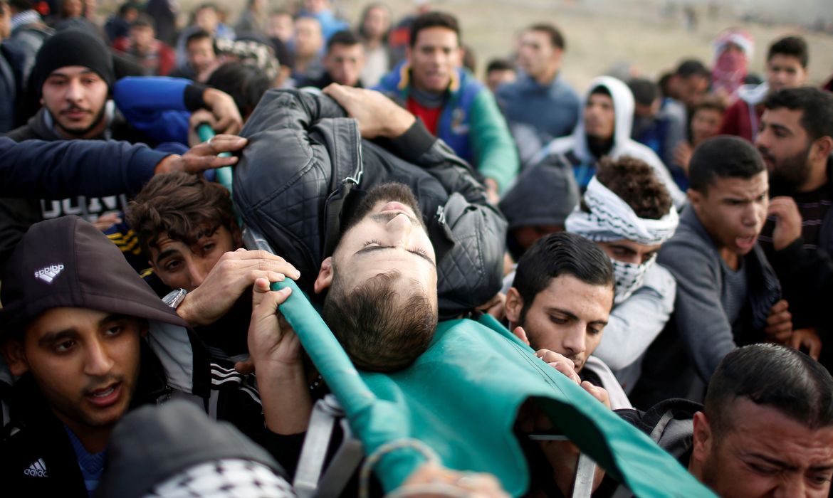 Palestino ferido é retirado de protesto em Gaza