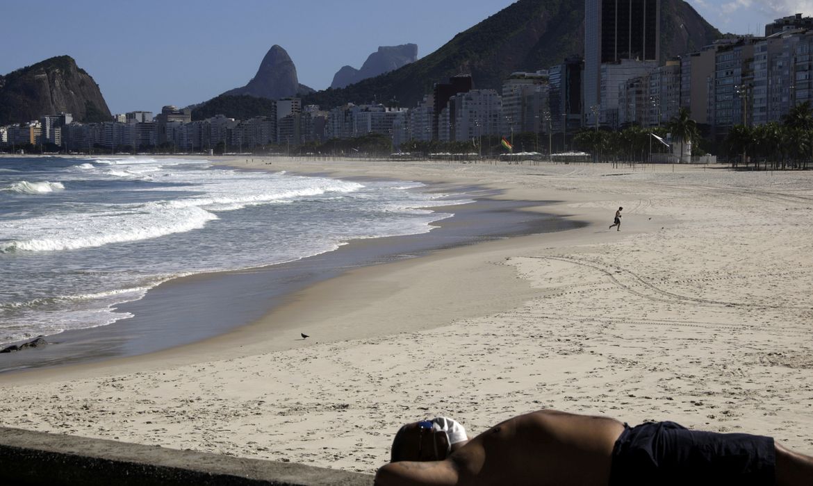 Um homem de máscara protetora relaxa na calçada da praia do Leme durante o surto de doença de coronavírus (COVID-19), no Rio de Janeiro, Brasil, 9 de maio de 2020. REUTERS / Ricardo Moraes