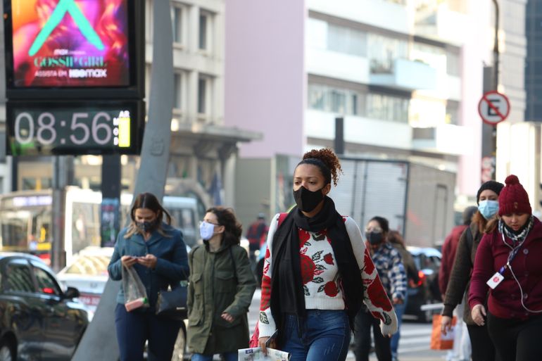 Pessoas saem agasalhadas em São Paulo, que registra baixas temperaturas por causa de uma frente fria.