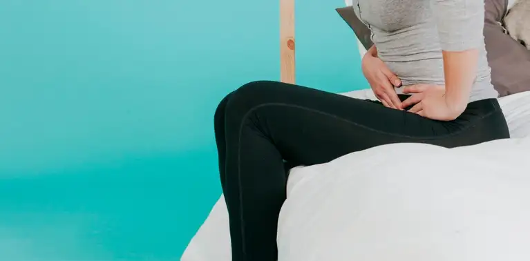 Mulher sentada com dor no ventre