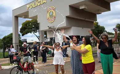 Anti-Bolsonaro demonstrators celebrate outside the Brazilian Federal Police Regional Headquarters, where Brazil's former President Jair Bolsonaro was taken after being placed in federal police custody as a preventative measure related to his house arrest, in Brasilia, Brazil, November 22, 2025. REUTERS/Mateus Bonomi