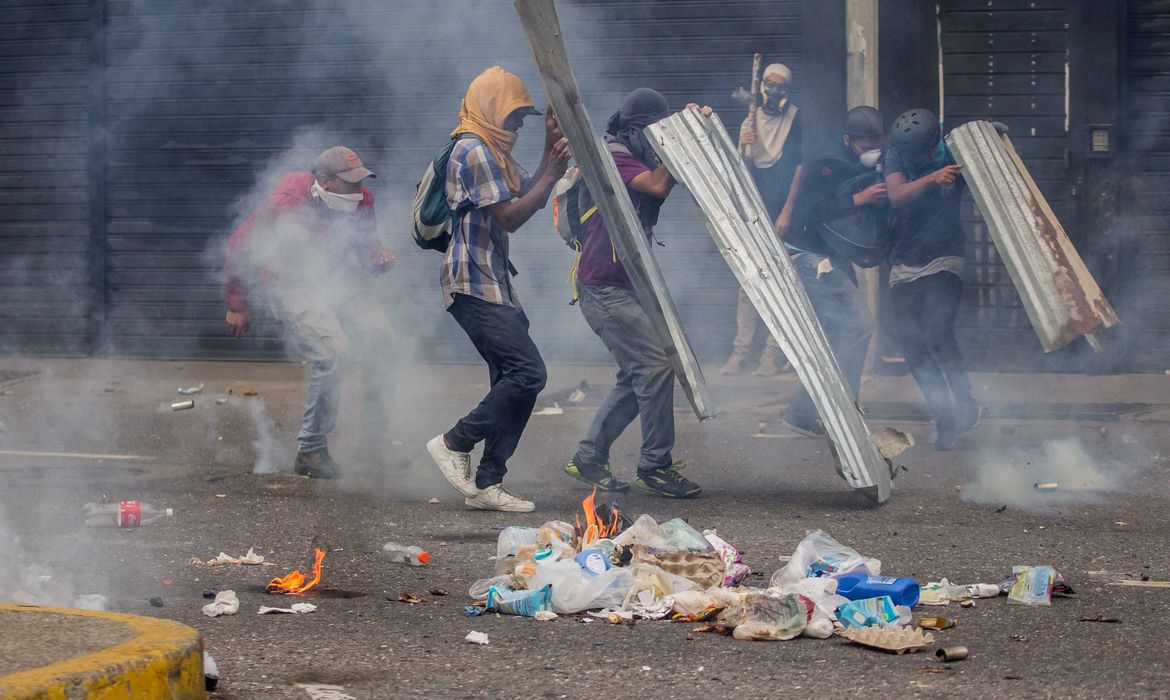 Manifestantes em Caracas, na Venezuela, entram em confronto com a Guarda Nacional do país, durante um protesto que pede a eleições no país e a saída de 