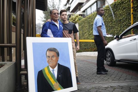 Roberto da Silva Pereira, militar da reserva da FAB, está em frente ao condomínio de Bolsonaro para entregar ao candidato um quadro que pintou em sua homenagem. Não conseguiu ser recebido, mas se disse satisfeito pela oportunidade de fazer