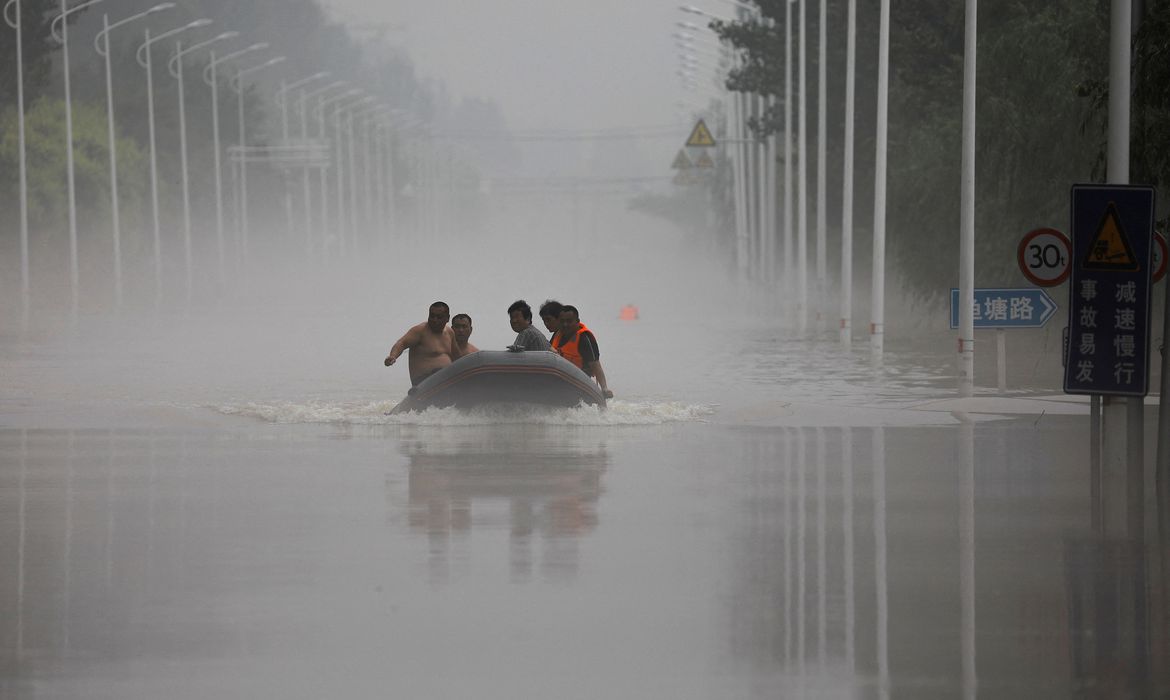 .Pessoas andam de barco por uma estrada inundada após as chuvas e inundações trazidas pelos remanescentes do tufão Doksuri, em Zhuozhou, província de Hebei, China
03/08/2023. REUTERS/Tingshu Wang/Foto de arquivo