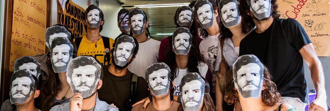 Estudantes comparecem a cerimônia da Comissão da Verdade na UnB com máscaras com a imagem do rosto de Honestino Guimarães, líder estudantil desaparecido durante o regime militar