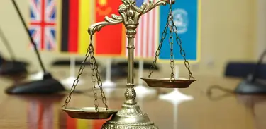 Balança símbolo da justiça em frente a bandeira de países 