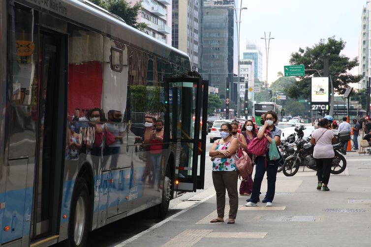 Usuários do transporte público esperam ônibus em ponto da Avenida Paulista, durante a fase vermelha da pandemia de covid-19 na capital.