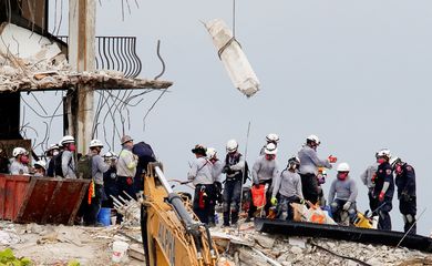 Emergency workers conduct search and rescue efforts at the site of a partially collapsed residential building in Surfside
