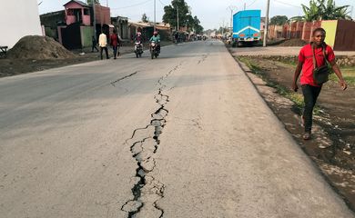 Pedestre caminha perto de uma rachadura na estrada causada por tremores de terra após a erupção do vulcão Monte Nyiragongo perto de Goma