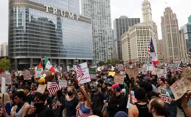 Demonstrators hold signs in front of Trump International Hotel and Tower, as they gather for a 