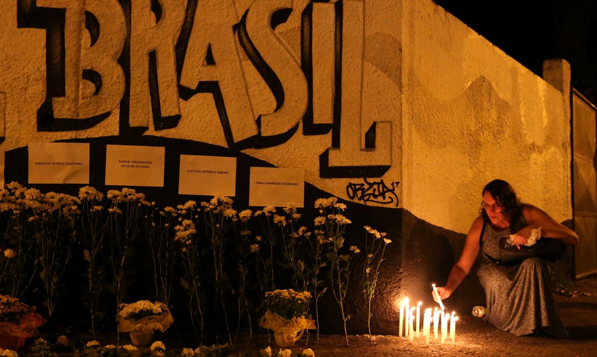 Uma mulher acende velas durante homenagem às vítimas do tiroteio na escola Raul Brasil em Suzano, São Paulo.