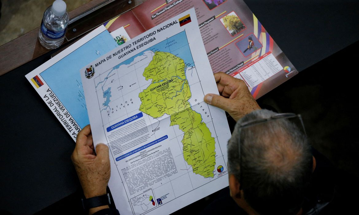 Membro da Assembleia Nacional da Venezuela segura um mapa que mostra a disputada região de Essequibo como parte da Venezuela
06/12/2023
REUTERS/Leonardo Fernandez Viloria