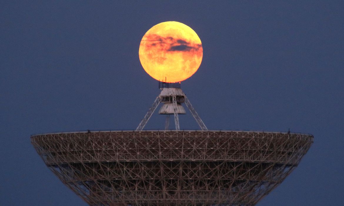A view shows the moon behind a radio telescope in Crimea