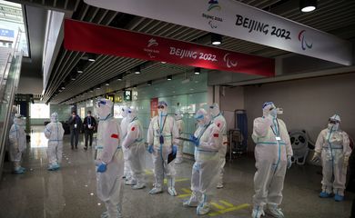Pessoas em trajes de proteção no aeroporto internacional de Pequim antes da Olimpíada de Inverno Pequim 2022 - Jogos - 