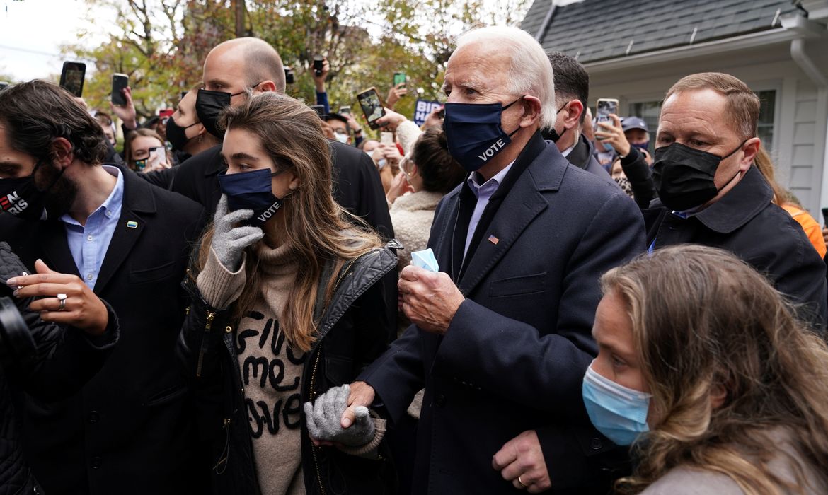 O candidato democrata dos EUA à presidência, Joe Biden, abre caminho no meio da multidão do lado de fora da casa de sua infância no dia da eleição em Scranton