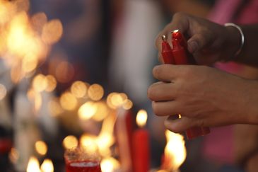 Devotos acendem velas na Igreja de São Gonçalo Garcia e São Jorge durante as celebrações ao Dia de São Jorge, no centro da cidade