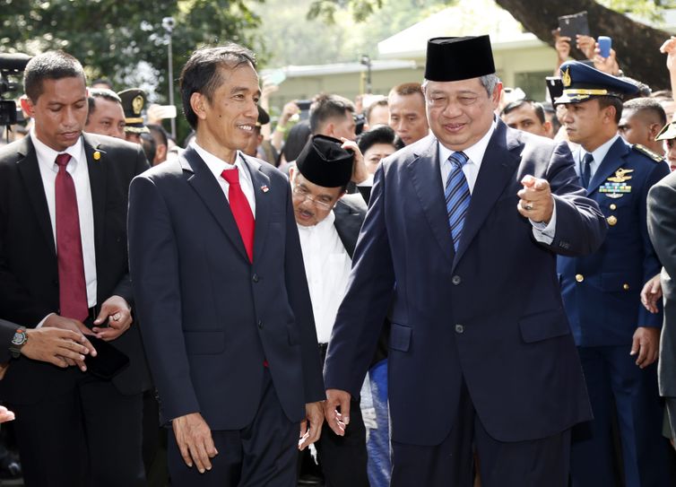 Novo presidente da Indonesia Joko Widodo (à esquerda) é cumprimentado pelo ex-presidente Susilo Bambang Yudhoyono (à direita) em uma cerimônia militar no palácio presidencial, na capital Jacarta