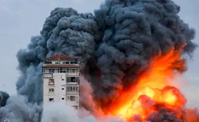 Fogo e fumaça saem de prédio após ataque de forças de Israel em Gaza. REUTERS/Ashraf Amra