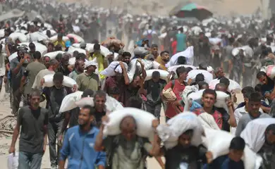GAZA CITY, GAZA - JULY 27: Palestinians walk for kilometers after receiving flour aid distributed from trucks that entered the Zikim area, a kibbutz in southern Israel, amid ongoing Israeli attacks and severe food shortages, in Gaza City, Gaza, on July 27, 2025. Mahmoud Issa / AnadoluNo Use USA No use UK No use Canada No use France No use Japan No use Italy No use Australia No use Spain No use Belgium No use Korea No use South Africa No use Hong Kong No use New Zealand No use Turkey