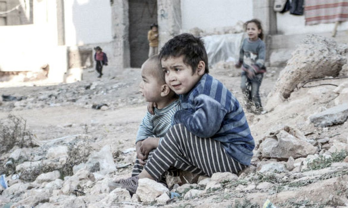 Crianças sírias perto de um abrigo para pessoas deslocadas