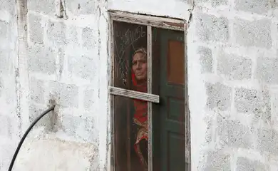 A woman looks out from a window of her home in Chakothi Village on the Line of Control (LoC) in Pakistan-administrated Kashmir, May 2, 2025. Reuters/Akhtar Soomro/Proibida reprodução