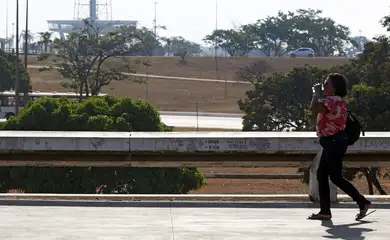 Brasília (DF), 03.09.2024 - Seca e alta temperatura em Brasília. Pessoa com copo de água passa pelo Setor de Diversões Sul.  Foto: Bruno Peres/Agência Brasil