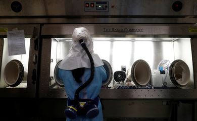 Um cientista da Agência de Ciência e Tecnologia da Equipe Doméstica (HTX) demonstra, sem uma amostra viva, o processo de extração do kit de teste de coronavírus em seu laboratório em Cingapura, em 5 de março de 2020. Esses kits de teste, uma