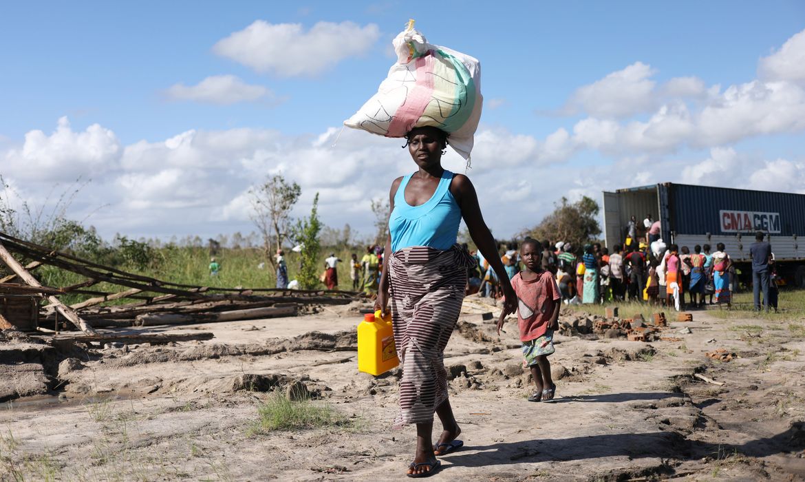 A Women walks after receiving parcel from an aid organisation after Cyclone Idai, near Dondo village outside Beira, Mozambique, March 24, 2019. REUTERS/Siphiwe Sibeko
