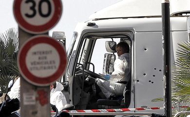 Policiais investigam a cabine do motorista do caminhão que se jogou sobre uma multidão de pessoas que comemoravam a data nacional da França, em Nice