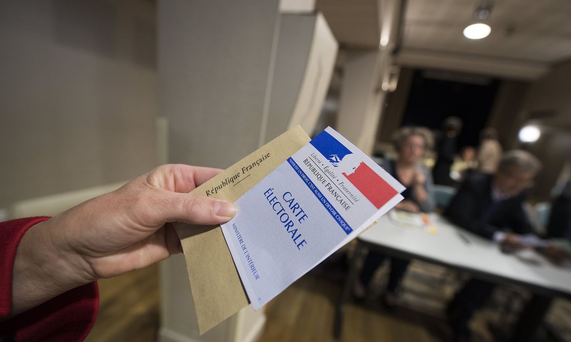 Eleitor mostra cédula de votação para eleição presidencial na França neste domingo 
