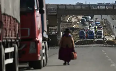 A woman walks among trucks stranded for days as protesters block a major highway, demanding the resignation of President Rodrigo Paz amid an ongoing economic and fuel crisis, in Apacheta, Bolivia, May 13, 2026. REUTERS/ Claudia Morales     TPX IMAGES OF THE DAY