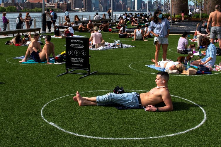 As pessoas tentam manter distância social enquanto desfrutam de uma tarde quente durante o surto da doença por coronavírus (COVID-19) no Domino Park, no Brooklyn, Nova York