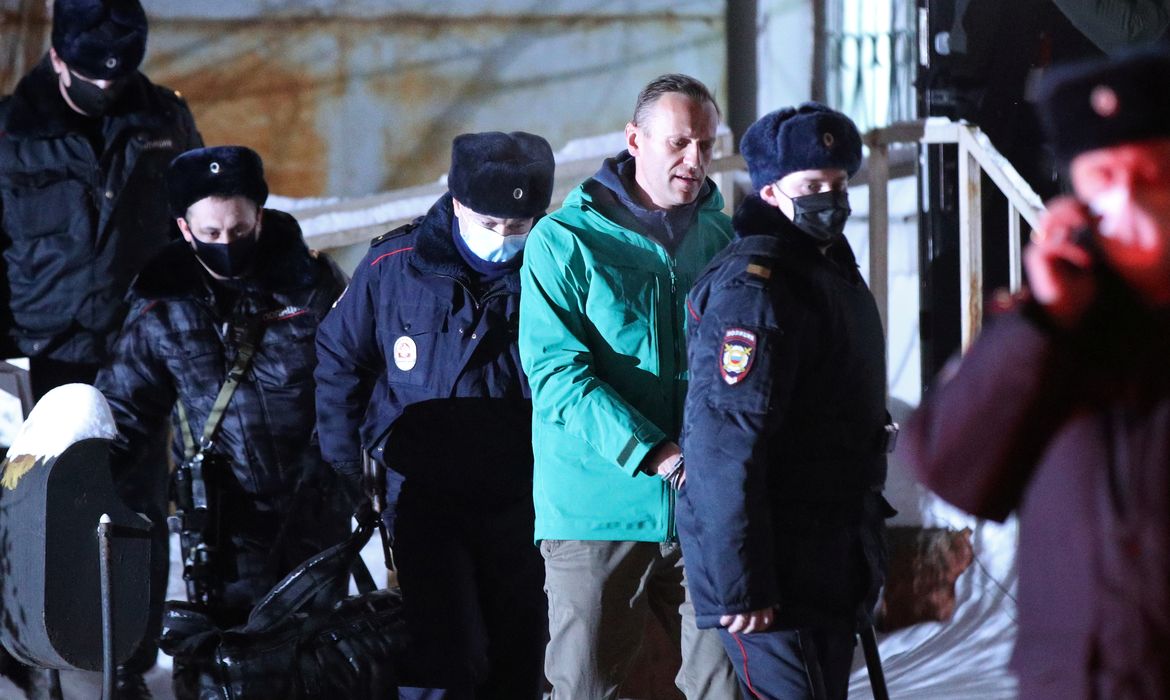 Russian opposition leader Alexei Navalny is escorted by police officers after a court hearing, in Khimki