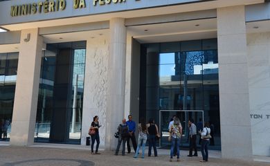 Brasília - Funcionários aguardam do lado de fora do prédio do Ministério da Pesca e Aquicultura,durante operação da PF que desarticulou uma rede que atuava  para concessão de permissões ilegais para pesca industrial (Jose Cruz/Agência