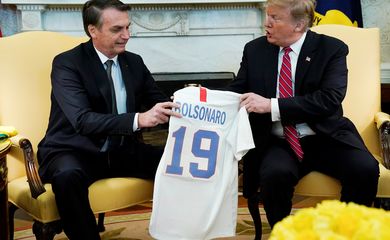 O presidente dos EUA, Donald Trump, dá ao presidente do Brasil, Jair Bolsonaro, uma camisa da seleção de futebol dos EUA durante uma reunião no Salão Oval da Casa Branca , em Washington (EUA). 