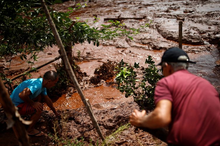 Residents work in a river covered by mud after a dam owned by Brazilian miner Vale SA that burst, in Brumadinho, Brazil January 26, 2019. REUTERS/Adriano Machado