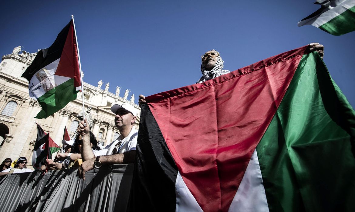 epa04753090 A man holds a Palestinian flag as he attends a canonization ceremony for new saints led by Pope Francis in St. Peter's Square, Vatican City, 17 May 2015. Palestinian Authority President Mahmoud Abbas is in the Vatican for the canonization of the Catholic Church's first Arabic-speaking saints - 19th century nuns Mariam Bawardy and Marie Alphonsine Ghattas, who lived in what was at the time Ottoman-ruled Palestine.  EPA/ANGELO CARCONI