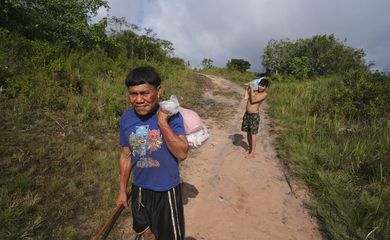 Surucucu (RR), 09/02/2023 - Pedro e Natanael, homens yanomami caminham com suprimentos em trilha no Surucucu, na Terra Indígena Yanomami.  Foto: Fernando Frazão/Agência Brasil
