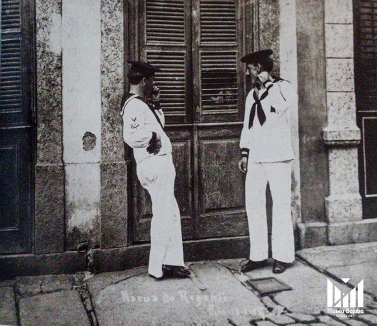 Rio de Janeiro (RJ) 27/06/2024 -  Orgulho LGBT - Marinheiros na porta de prostíbulo 1908 -
Foto: Augusto Malta/Museu Bajubá/Divulgação